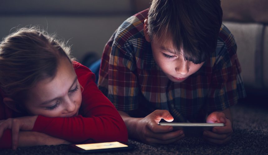 Girl and boy with their smart phones Talking to your kids about “MOMO”